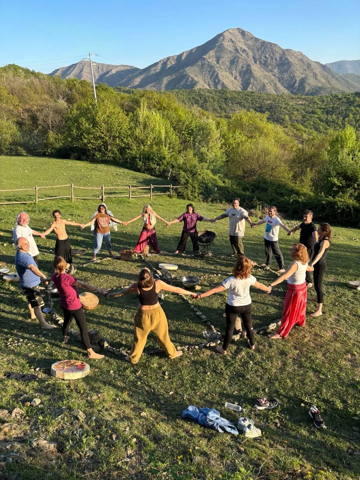 Il gruppo in cerchio, mano nella mano, su un prato di montagna