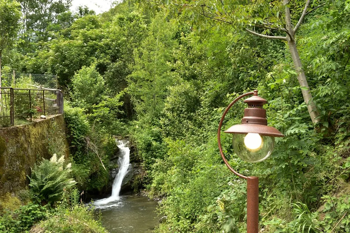 Il torrente che scende a cascata tra i boschi, sotto la casa di Libera Vite